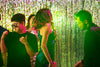 Students at homecoming in front of a gold foil curtain.