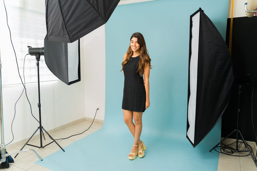 Model waiting to take headshots in front of a blue background.