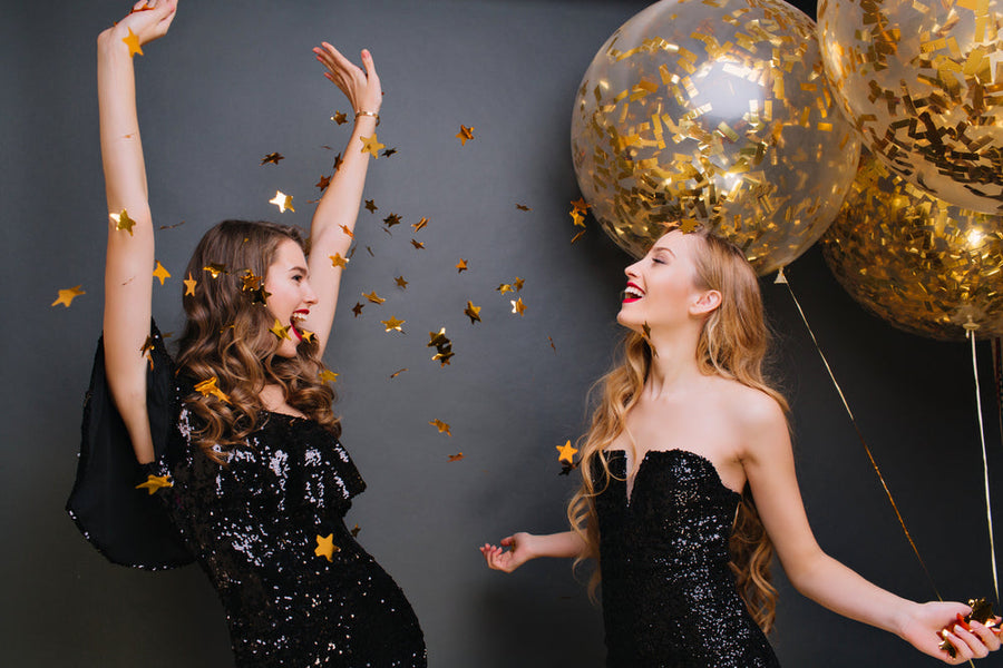 blonde girl in black outfit holding party balloons and looking at friend, Birthday Dinner Outfit Ideas