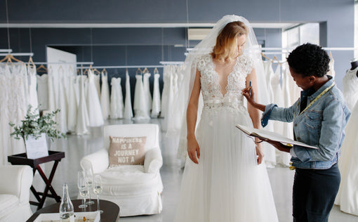 Dress designer fitting bridal gown to woman in boutique, Bridal Dress Appointment