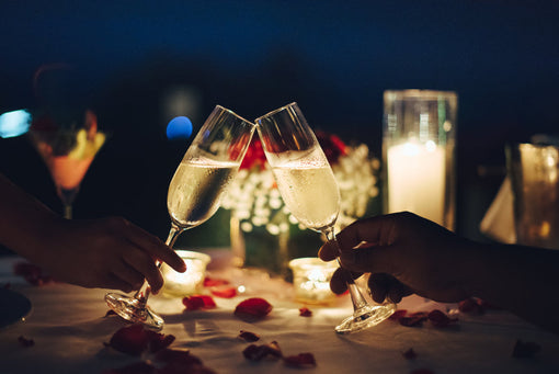 couple clinking glasses during romantic valentines candlelight dinner
