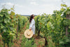 Joyful woman wearing a hat in a vineyard in the sun, What to Wear to a Winery