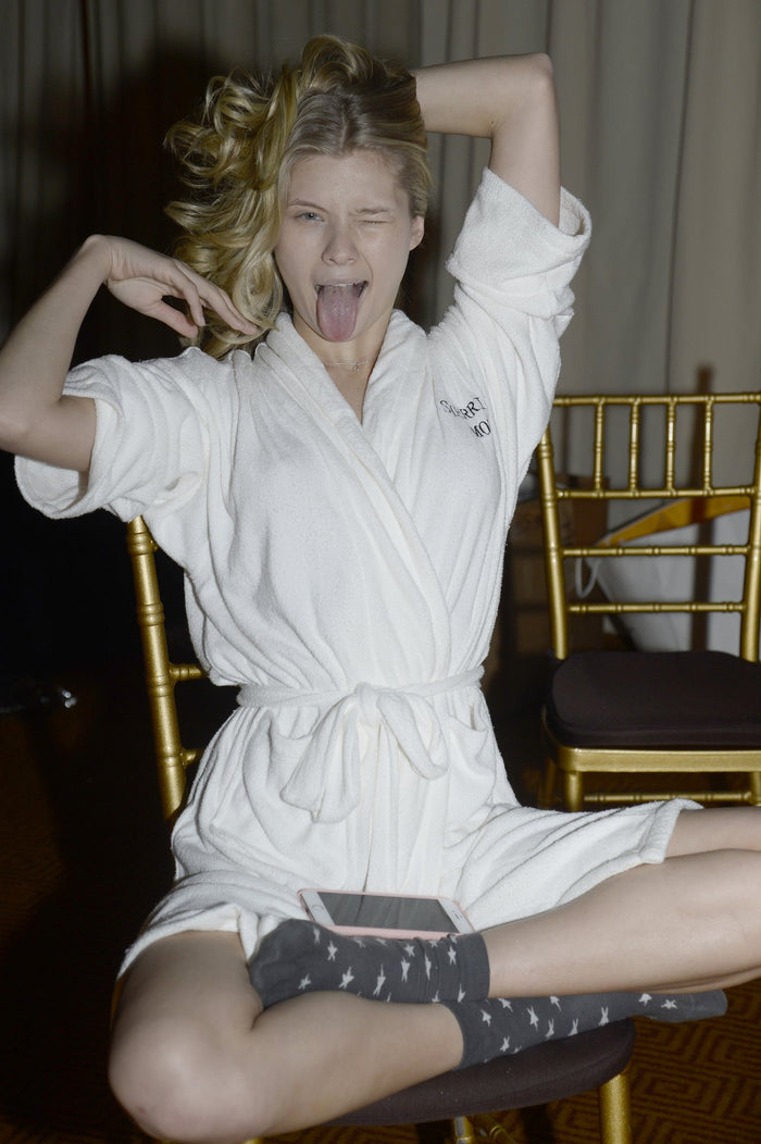 Model Josie Canseco in a white Sherri Hill robe strikes a pose backstage