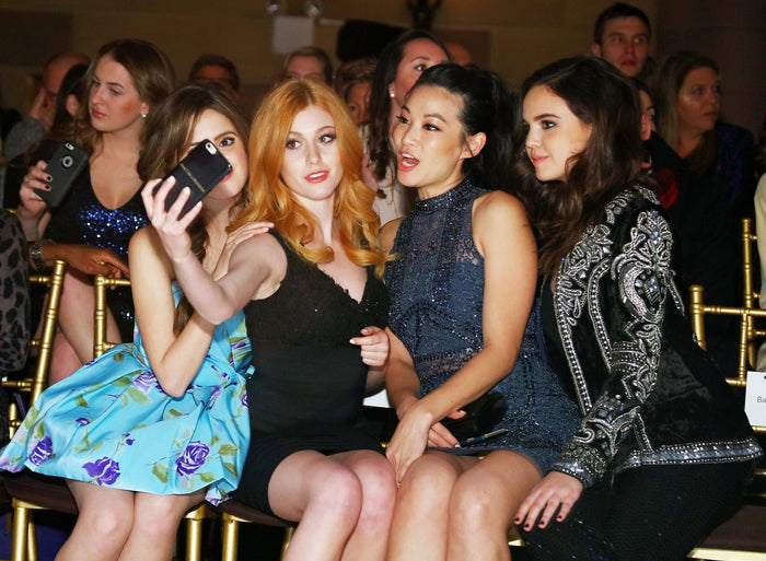 Actress Laura Marano and guests in the front row before the show