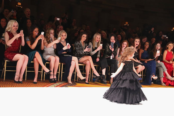 Dove Cameron, Bethany Mota, Brec Bassinger, Jordyn Jones and Danielle Campbell watch as Taylen Biggs walks the runway