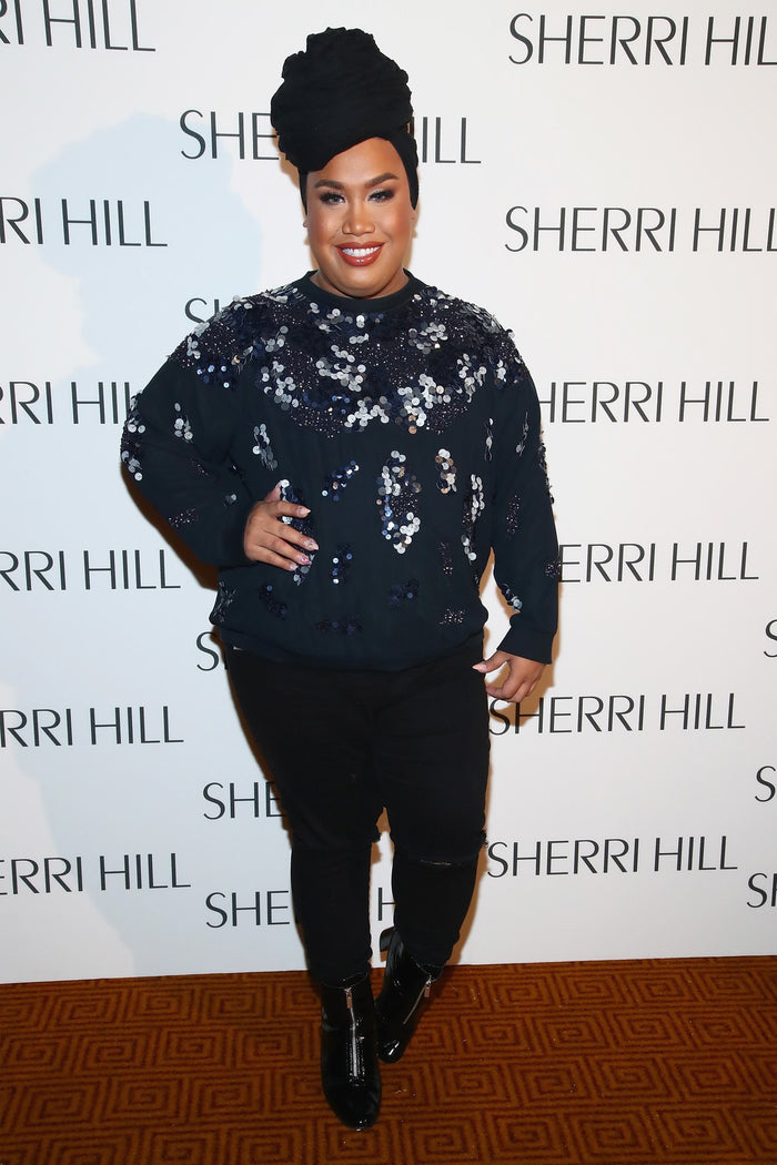 A guest in a sequinned sweater on the red carpet