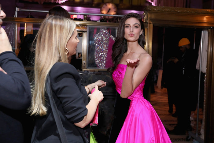 A model in the hot pink taffeta gown waits in line backstage