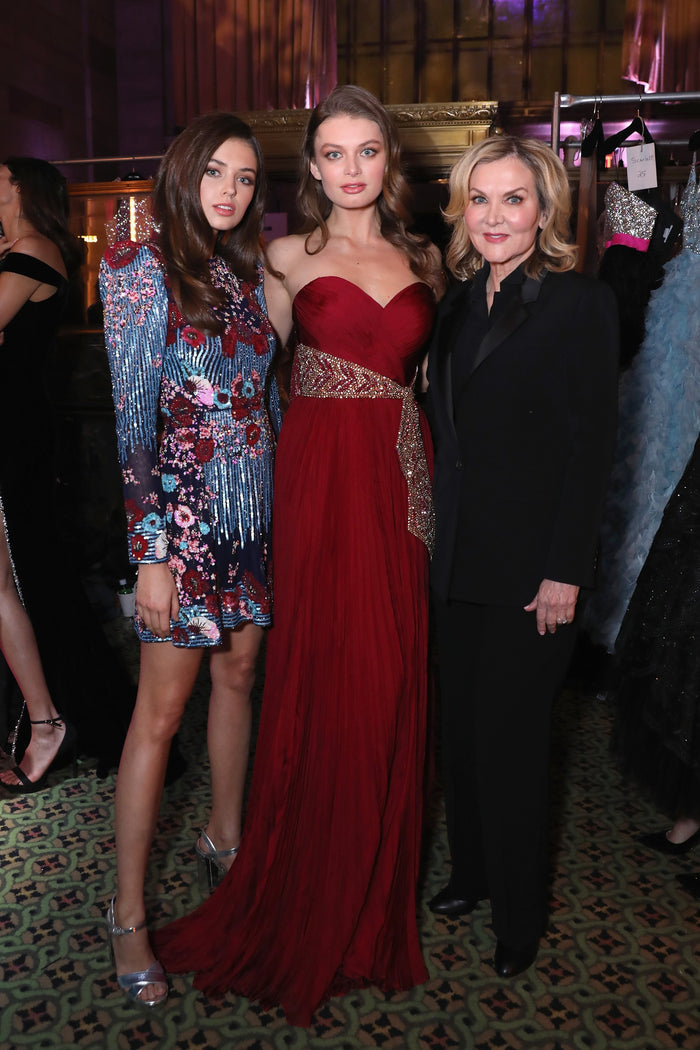 Sherri Hill with two models in a multicolour beaded mini and a red gown