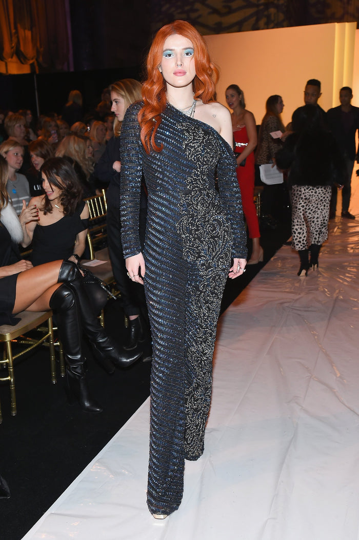 A guest in a black beaded long-sleeve jumpsuit on the runway before the show