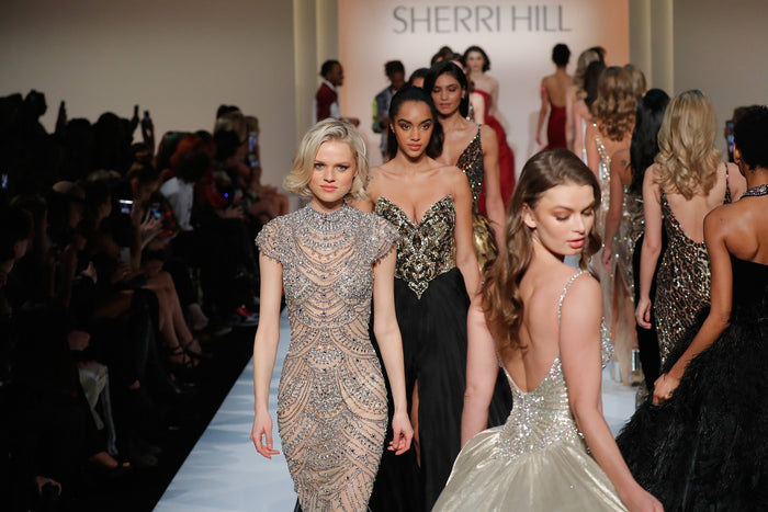 The gold finale gowns walk past the front row