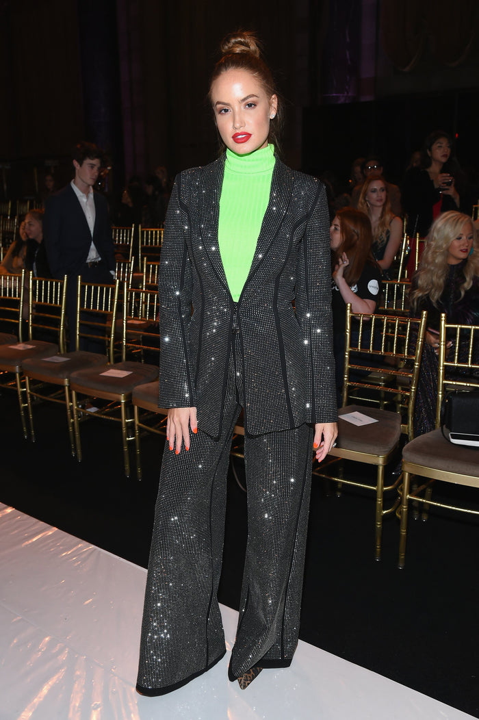 Haley Baylee in a sequin suit and neon top in the front row