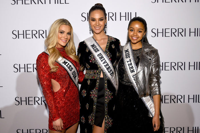 Three titleholders in their sashes on the red carpet
