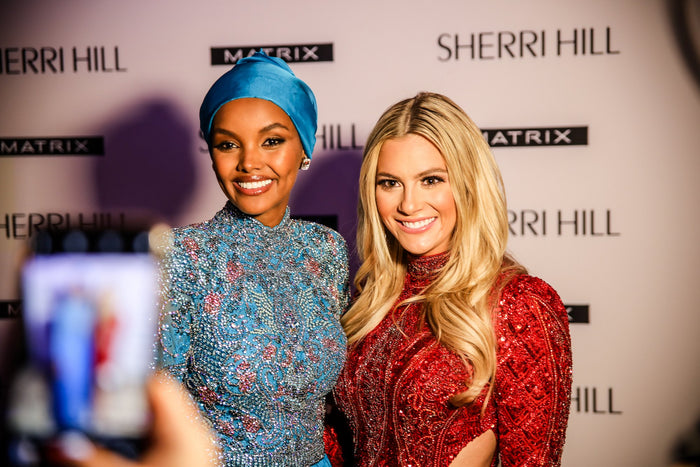 Two guests pose for a phone photo on the red carpet