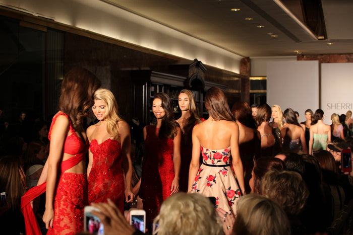 Models walk the runway, seen from the front row
