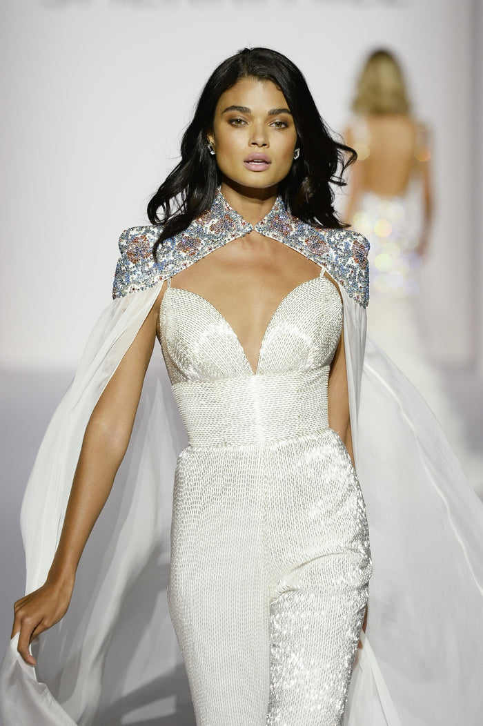 Model Daniela Braga in the finale look, a white jumpsuit with a crystal-beaded cape, on the runway