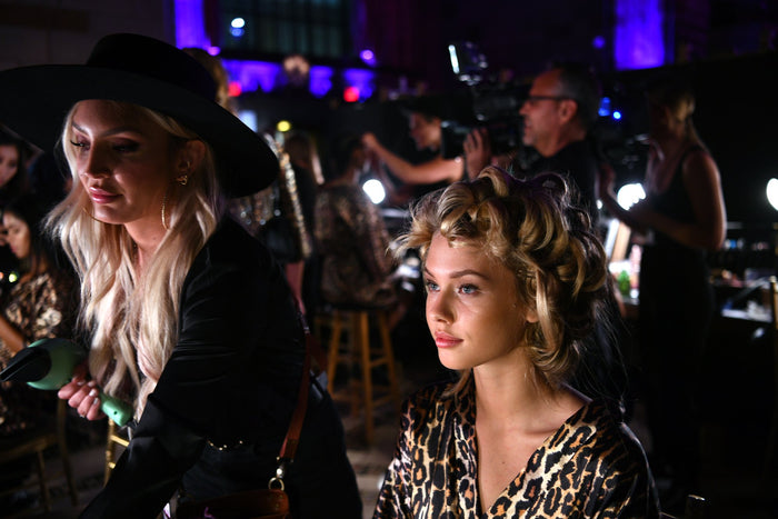 A model in a leopard-print Sherri Hill robe in hair and makeup backstage at Cipriani