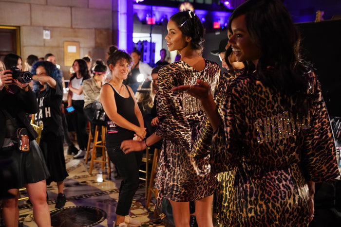 Models in leopard-print robes backstage before the show