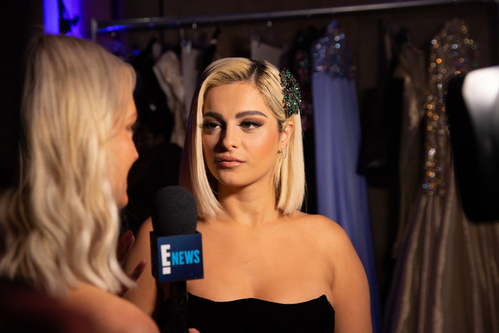 An interview backstage in front of the racks of gowns