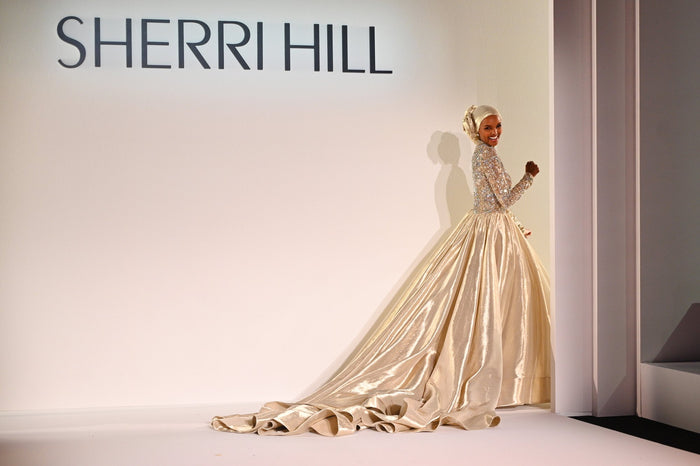 The finale gown, a gold ballgown, at the top of the runway