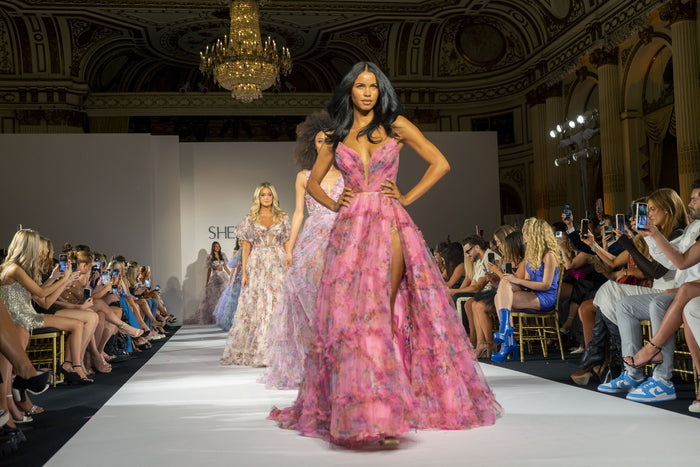 Model Daiane Sodre in a floral gown comes down the runway under the chandeliers at The Plaza
