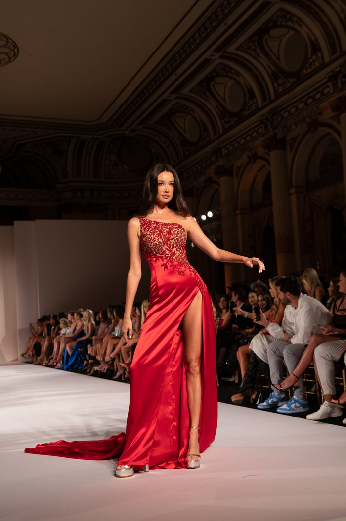 A red beaded gown with a high slit on the runway