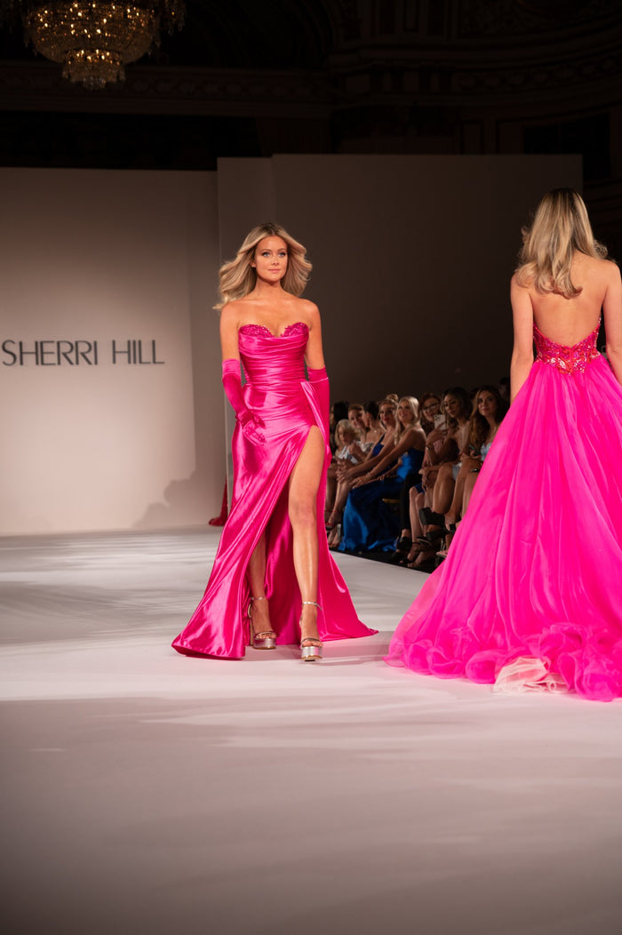 Model Hannah Godwin in hot pink satin on the runway, seen from the front row